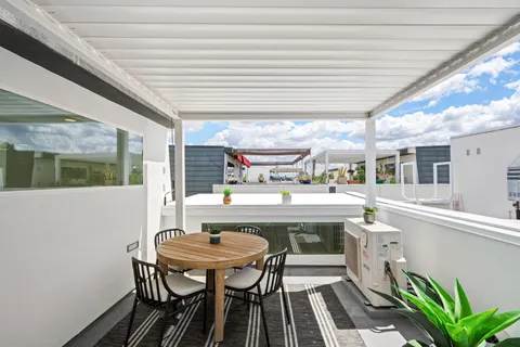 a view of a terrace with furniture and a garden