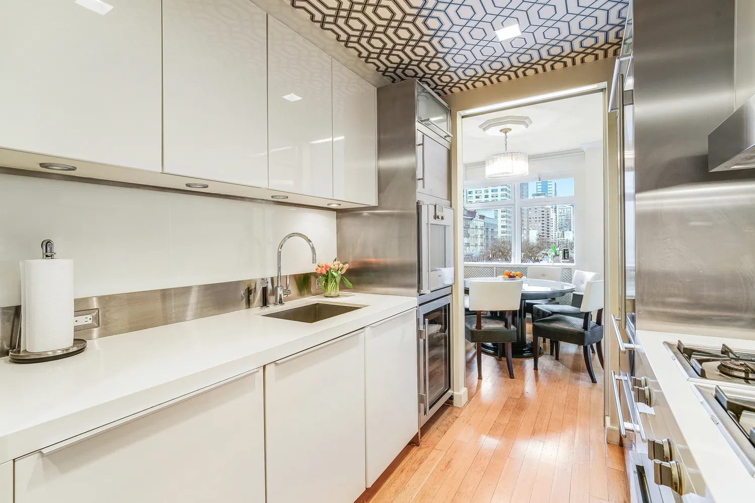 a kitchen with sink a stove and chairs