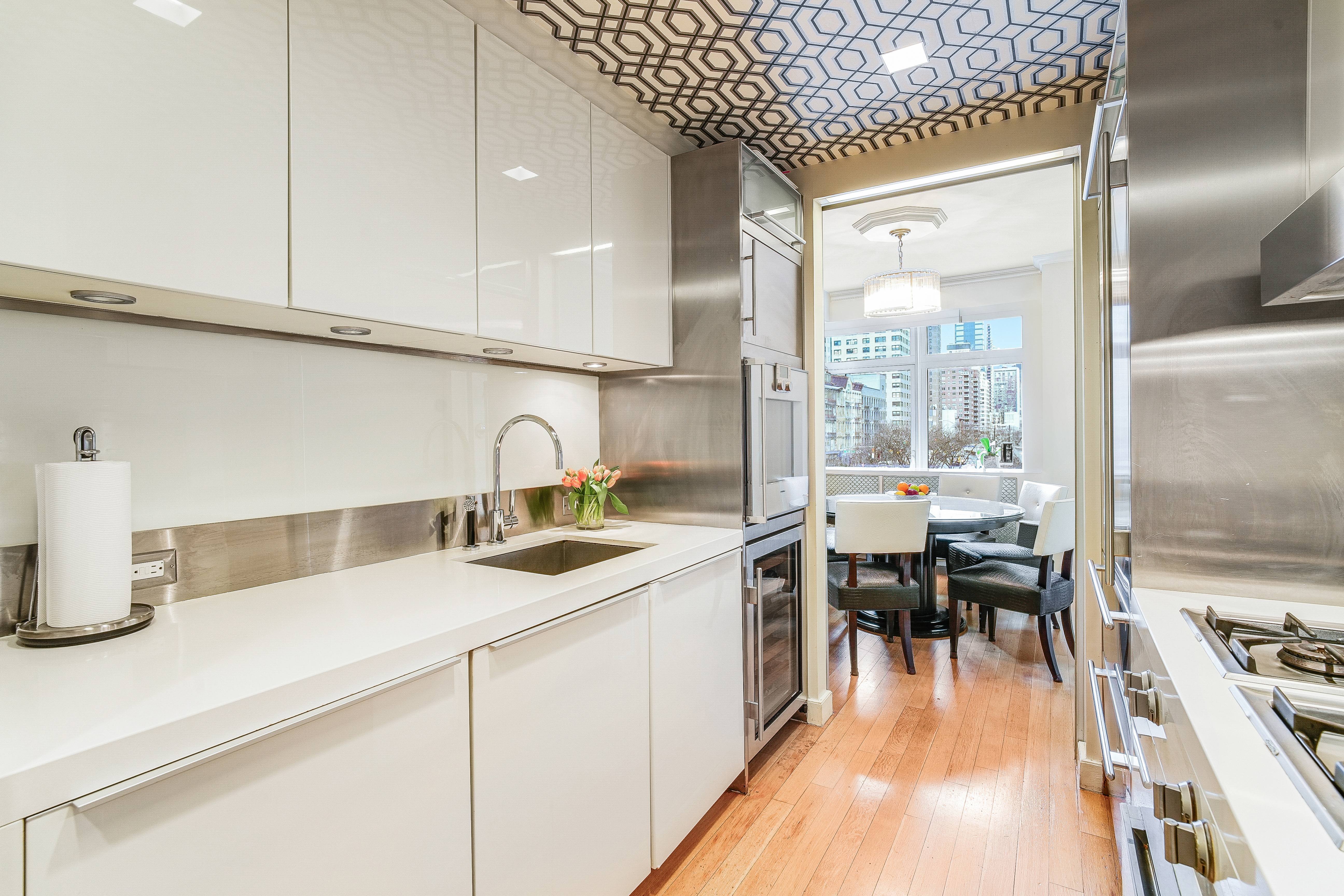 400 East 67th Street, Unit 3CD Manhattan, NY 10065 - Photo 7 of 28 a kitchen with sink a stove and chairs
