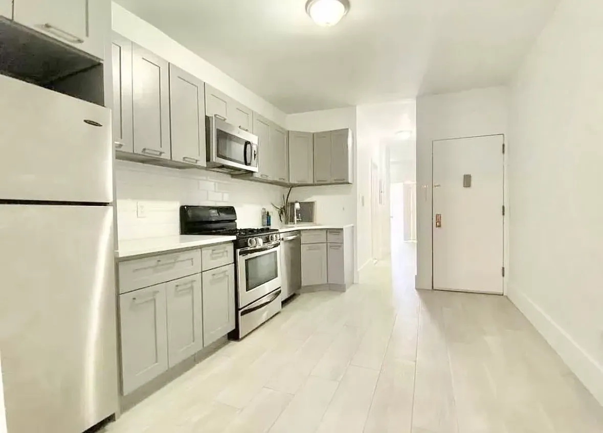 a kitchen with white cabinets and white appliances