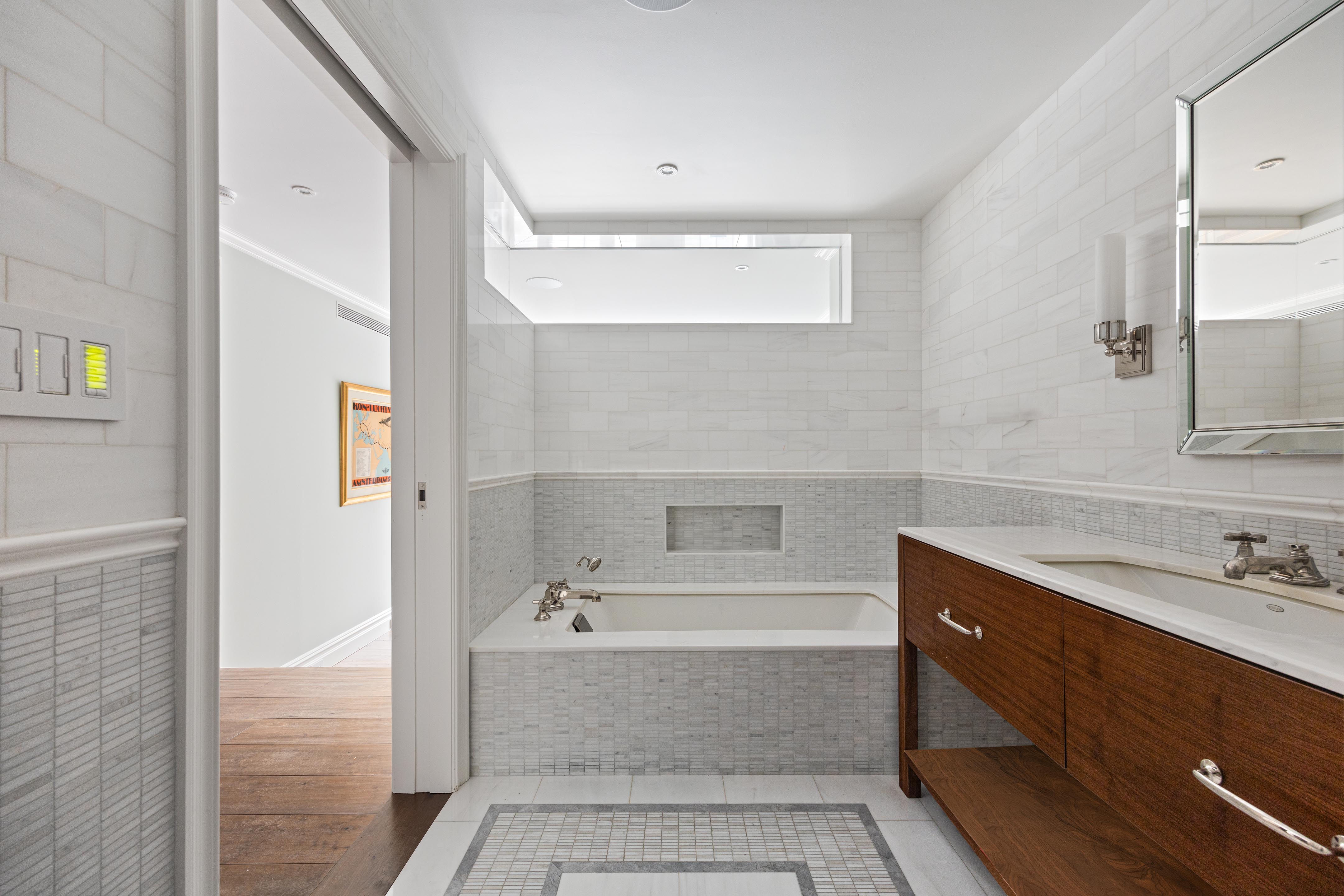 14 West 11th Street, Unit GARDEN Manhattan, NY 10011 - Photo 10 of 18 a bathroom with a tub sink and mirror