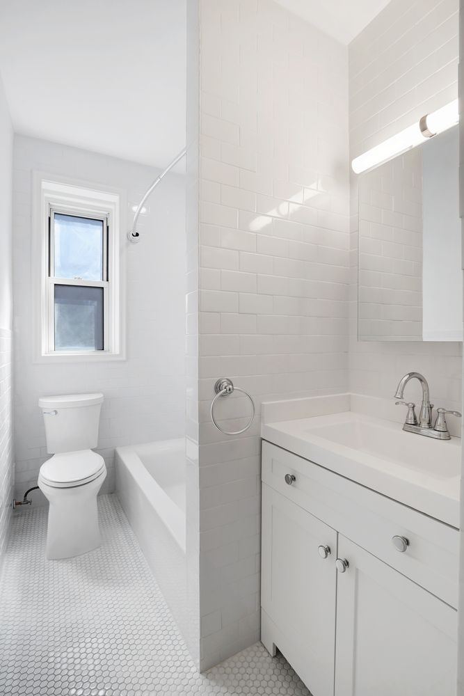 300 West 53rd Street, Unit 3C Manhattan, NY 10019 - Photo 7 of 10 a bathroom with a sink a toilet and shower