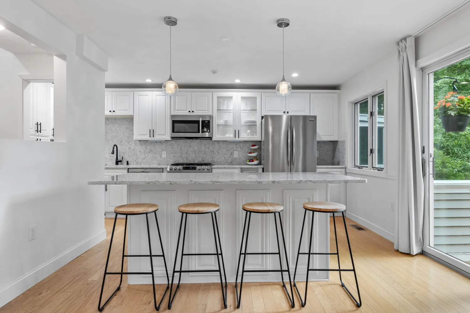 a kitchen with kitchen island granite countertop wooden floor cabinets and a refrigerator
