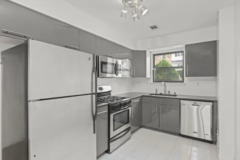 a white kitchen with stainless steel appliances granite countertop a refrigerator sink and stove
