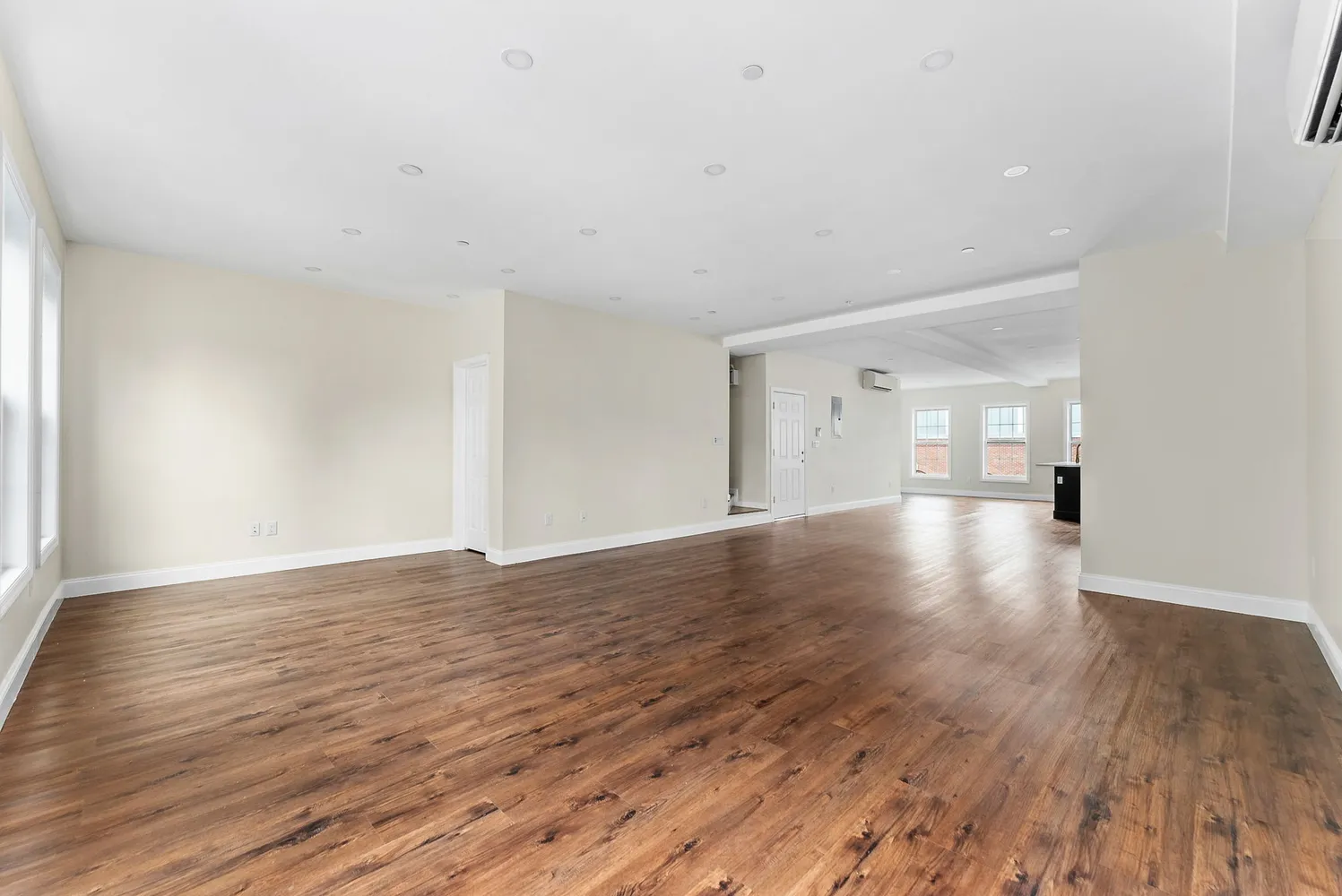 a view of empty room with wooden floor