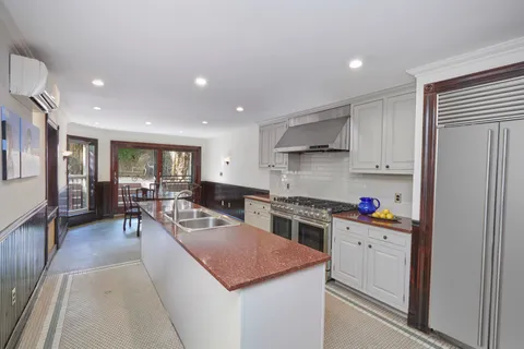 a kitchen that has a lot of cabinets in it and wooden floors