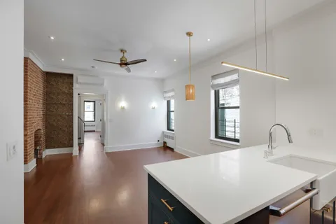 a view of a kitchen with a sink dishwasher a refrigerator and wooden floor