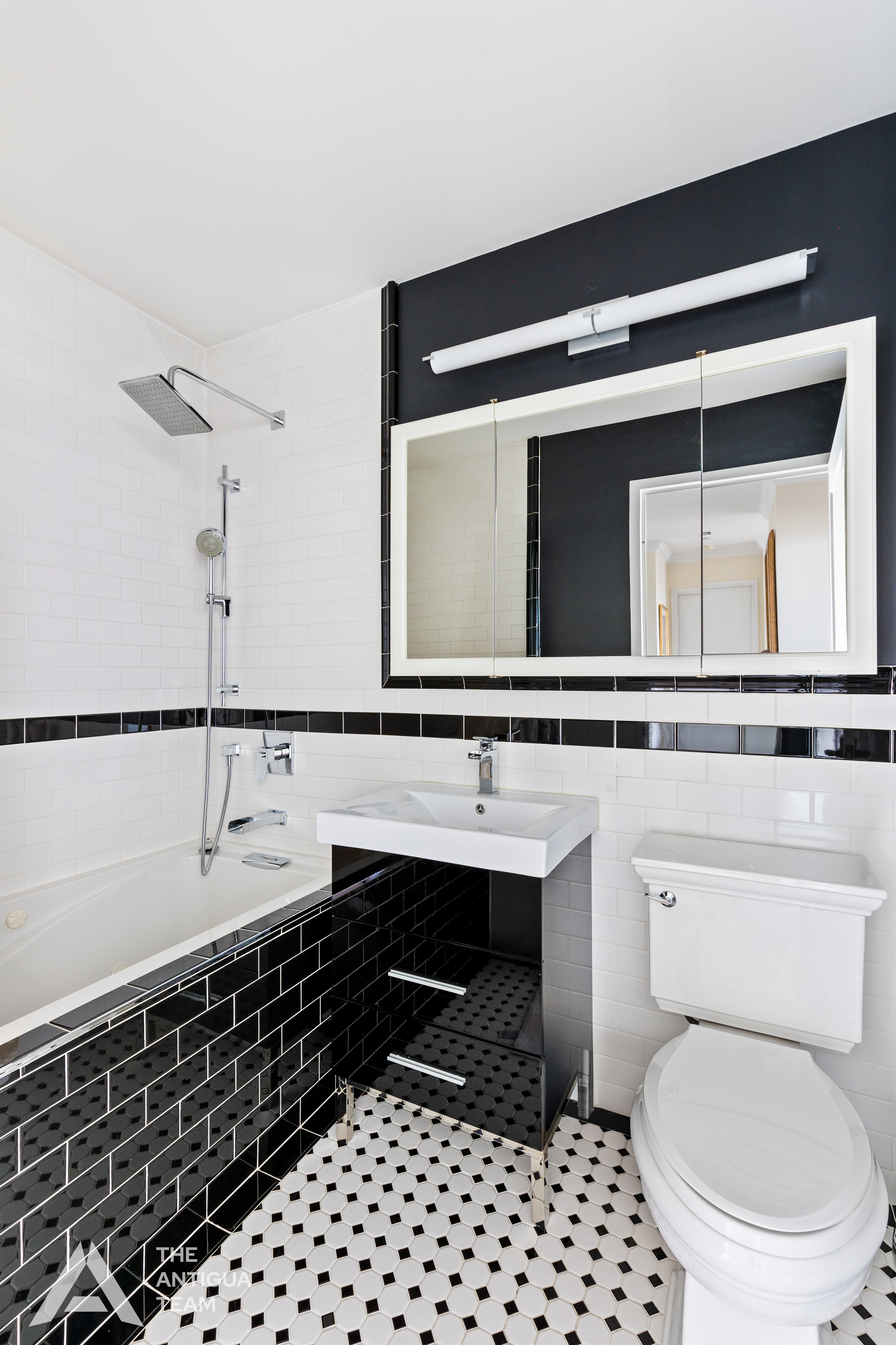 635 West 42nd Street, Unit 23E Manhattan, NY 10036 - Photo 8 of 16 a bathroom with a sink a toilet and mirror