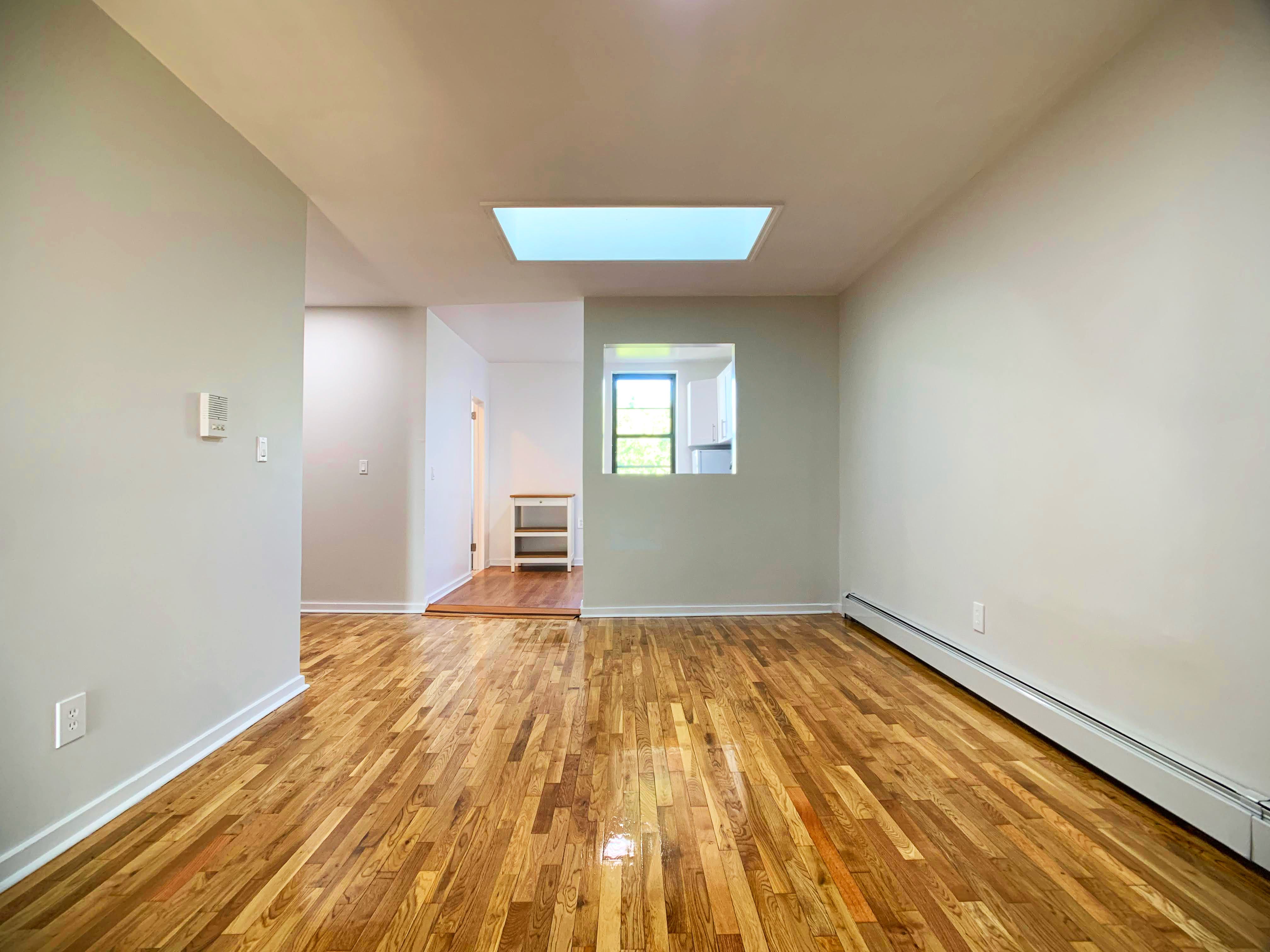 293 Tompkins Avenue Brooklyn, NY 11221 - Photo 17 of 19 a view of a room with wooden floor and a window