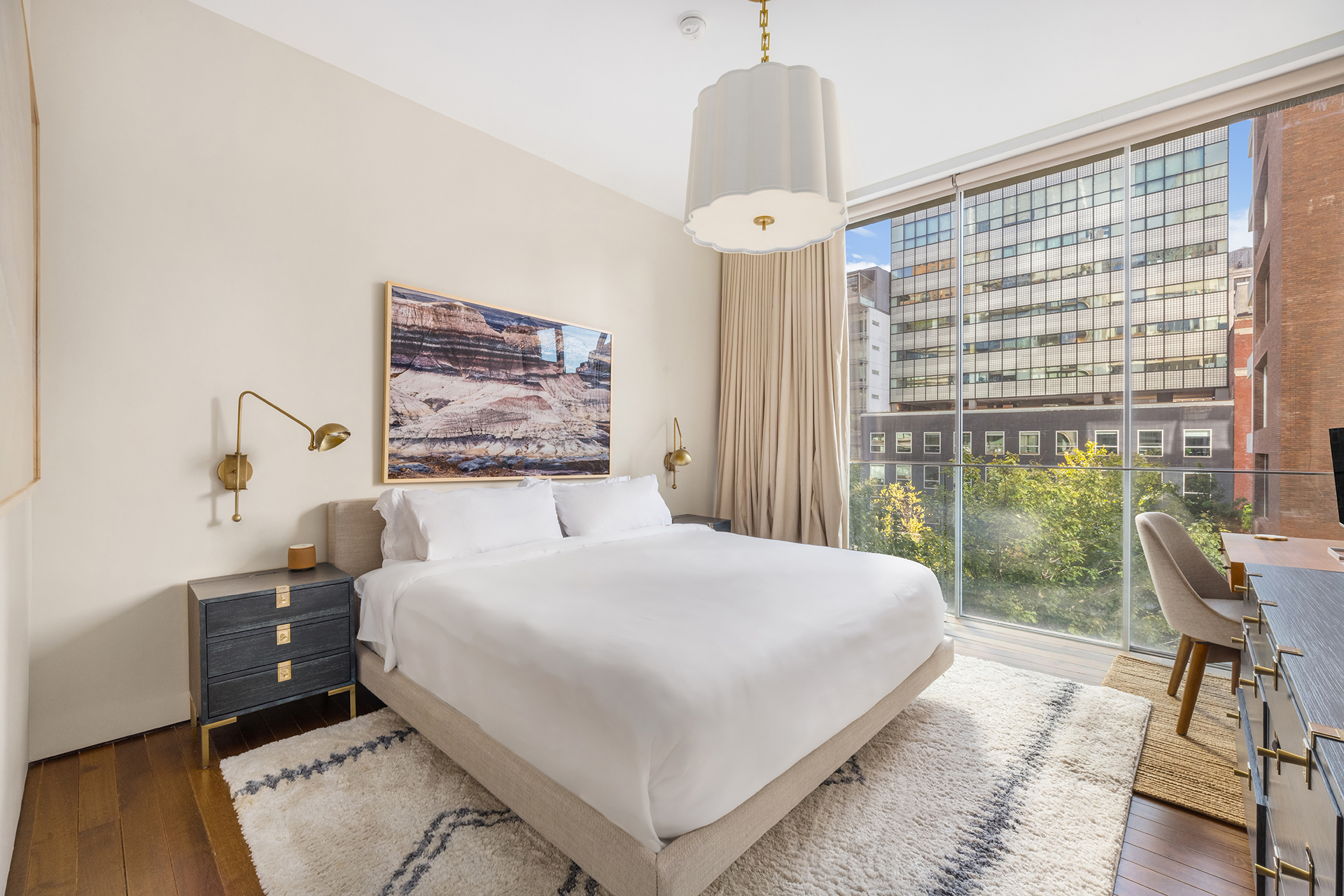 527 West 27th Street, Unit 4C Manhattan, NY 10001 - Photo 10 of 25 a bedroom with a large bed and a chandelier