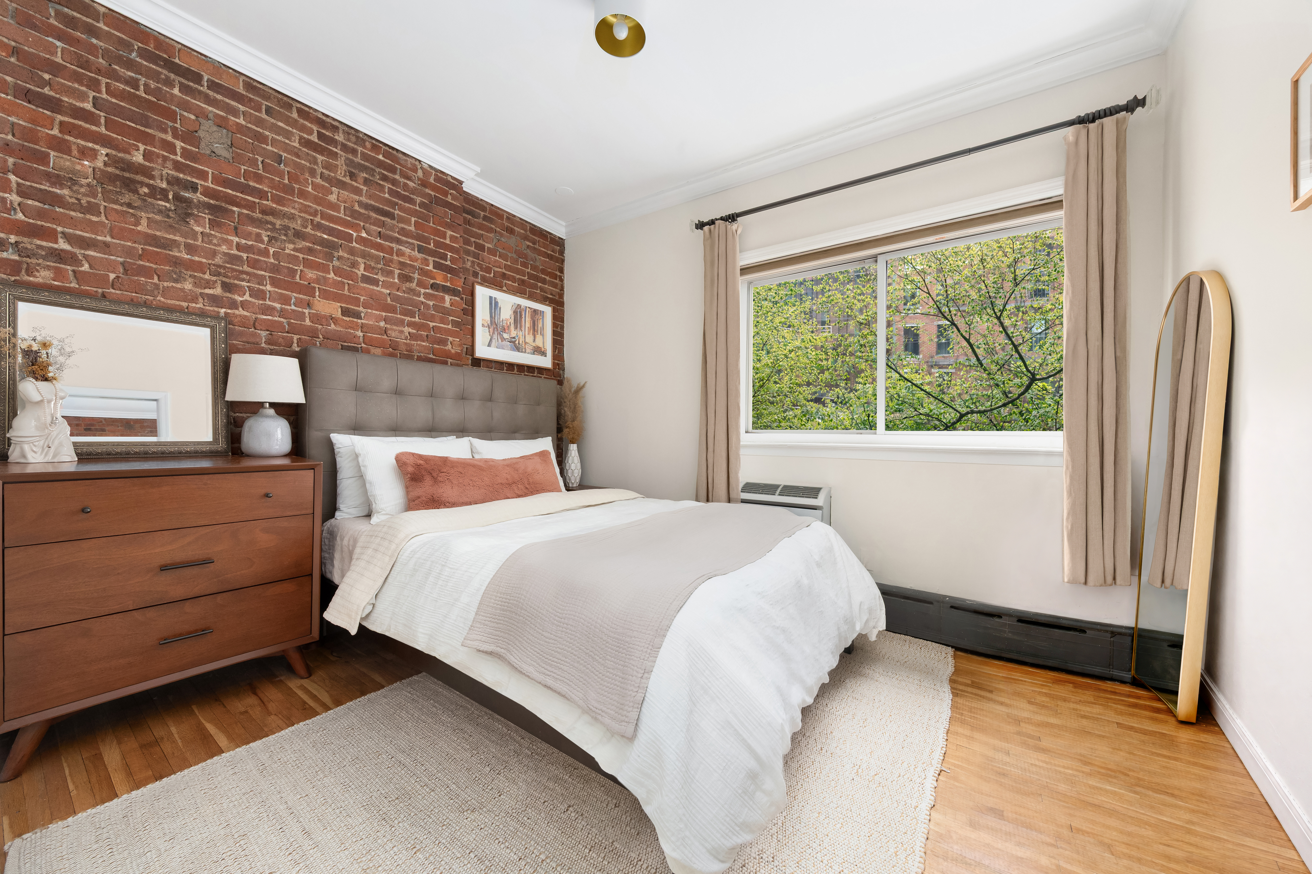 207 East 21st Street, Unit 5B Manhattan, NY 10010 - Photo 3 of 7 a bedroom with a bed and a window