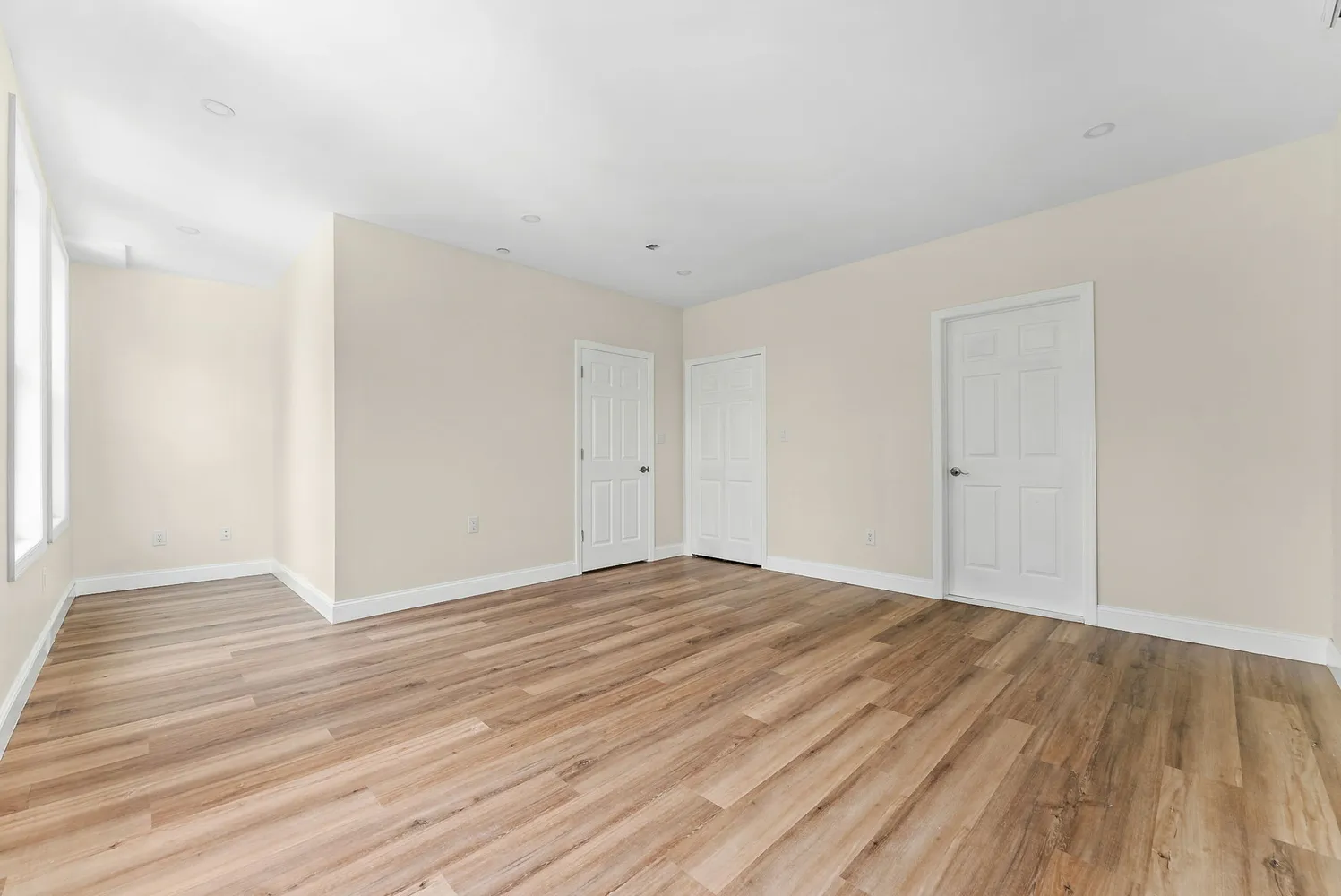 a view of an empty room with wooden floor