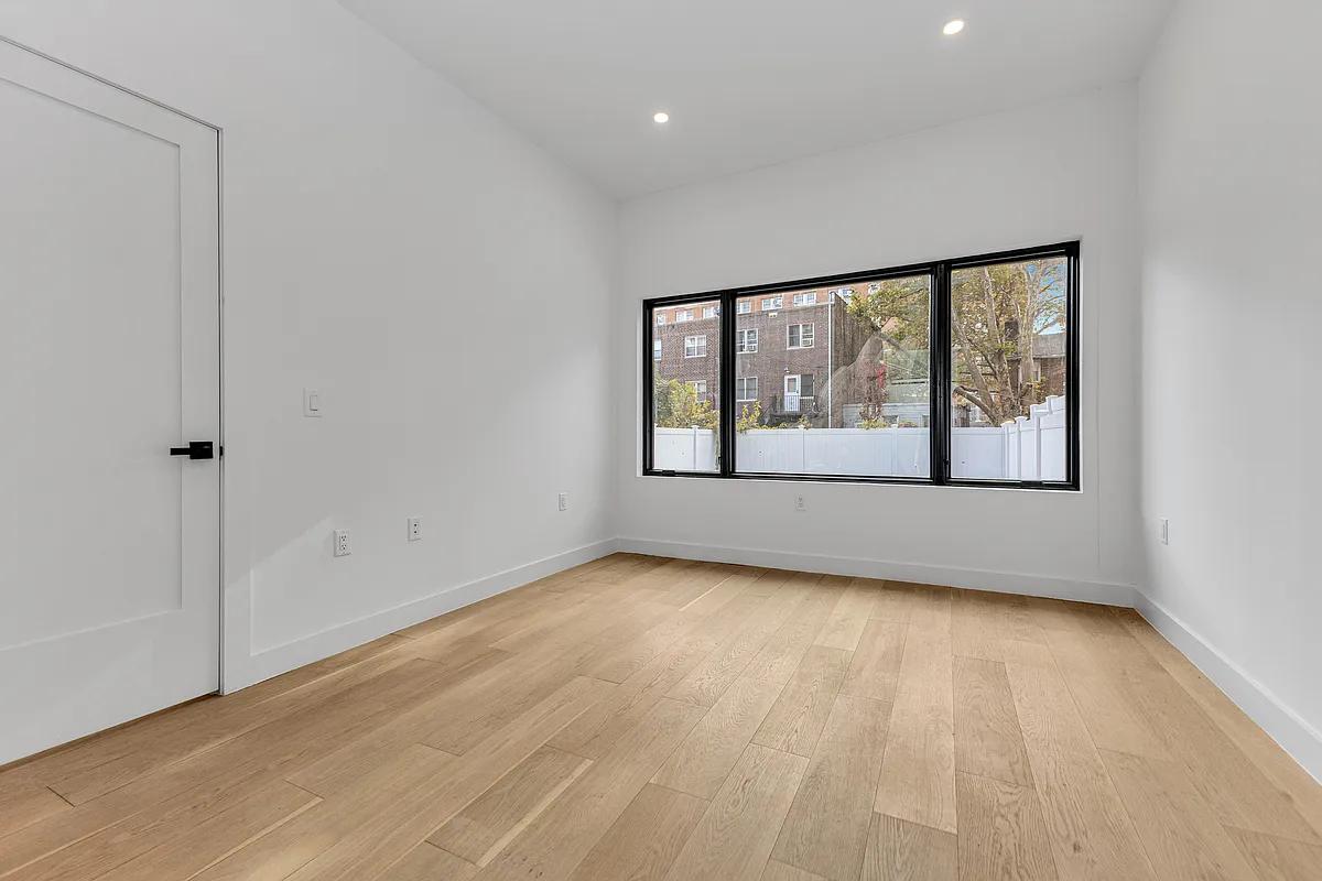 21-10 30th Avenue, Unit 1R Queens, NY 11102 - Photo 5 of 16 wooden floor in an empty room with a window