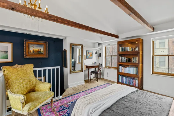 a bedroom with a bed furniture and a book shelf