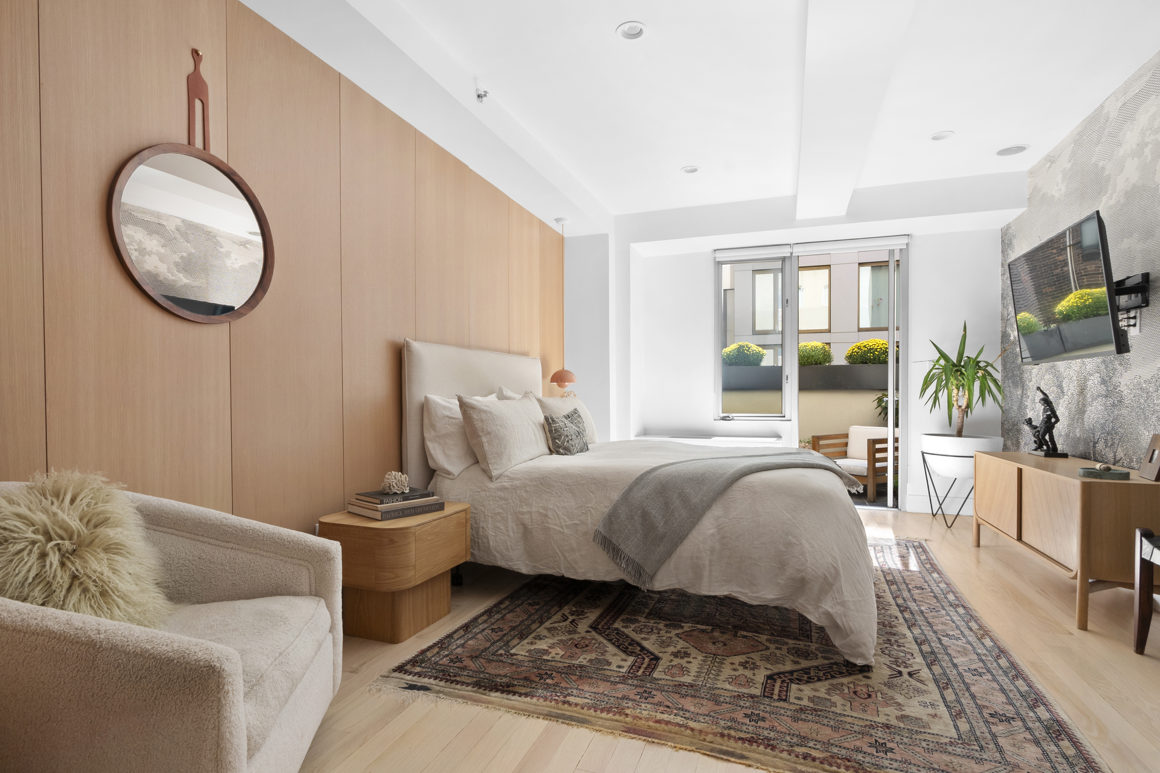 116 West 22nd Street, Unit 5 Manhattan, NY 10011 - Photo 7 of 15 a spacious bedroom with a bed a couch and a flat tv screen