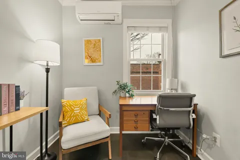 a view of a workspace with furniture and a window