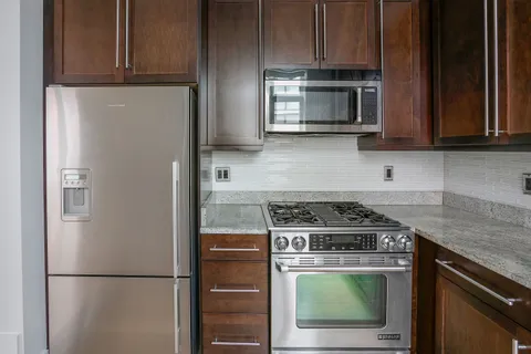 a kitchen with stainless steel appliances granite countertop a refrigerator stove and microwave