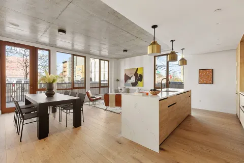 a large living room with stainless steel appliances granite countertop a table chairs and a large window