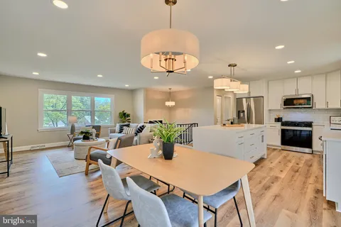 a kitchen with sink refrigerator dining table and chairs