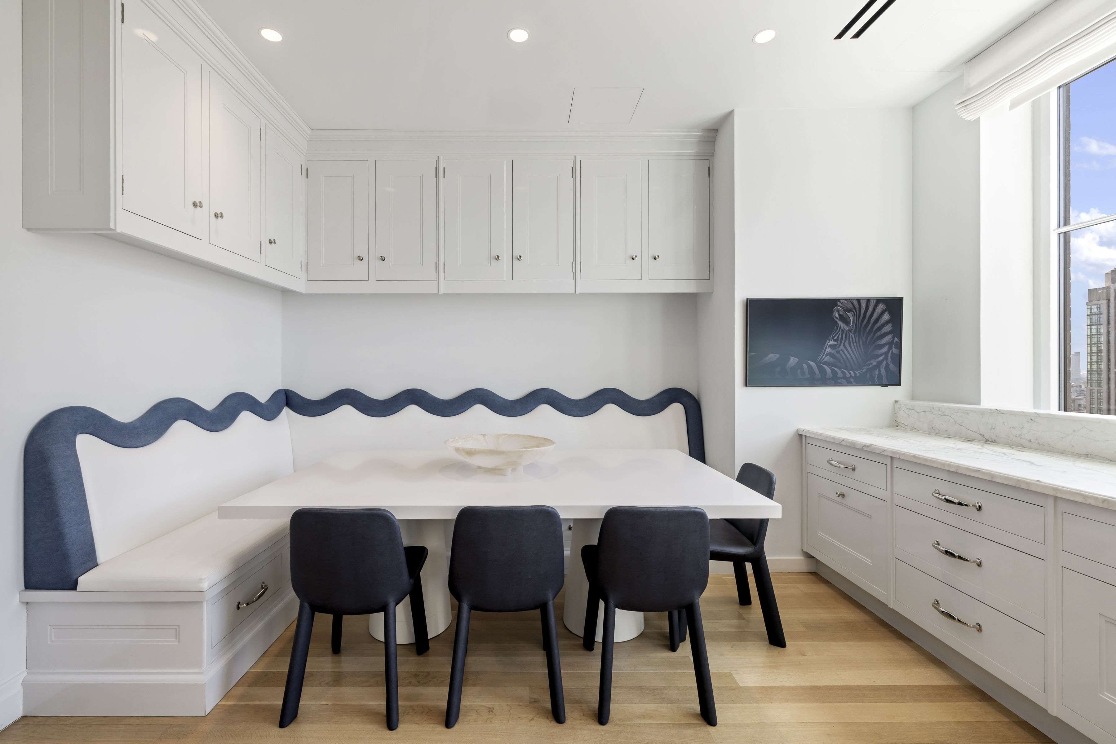 301 East 80th Street, Unit 25B Manhattan, NY 10075 - Photo 9 of 38 a kitchen with granite countertop a table chairs and a refrigerator