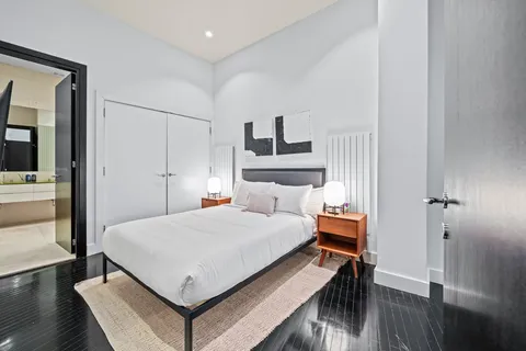 a bedroom with a bed and wooden floor