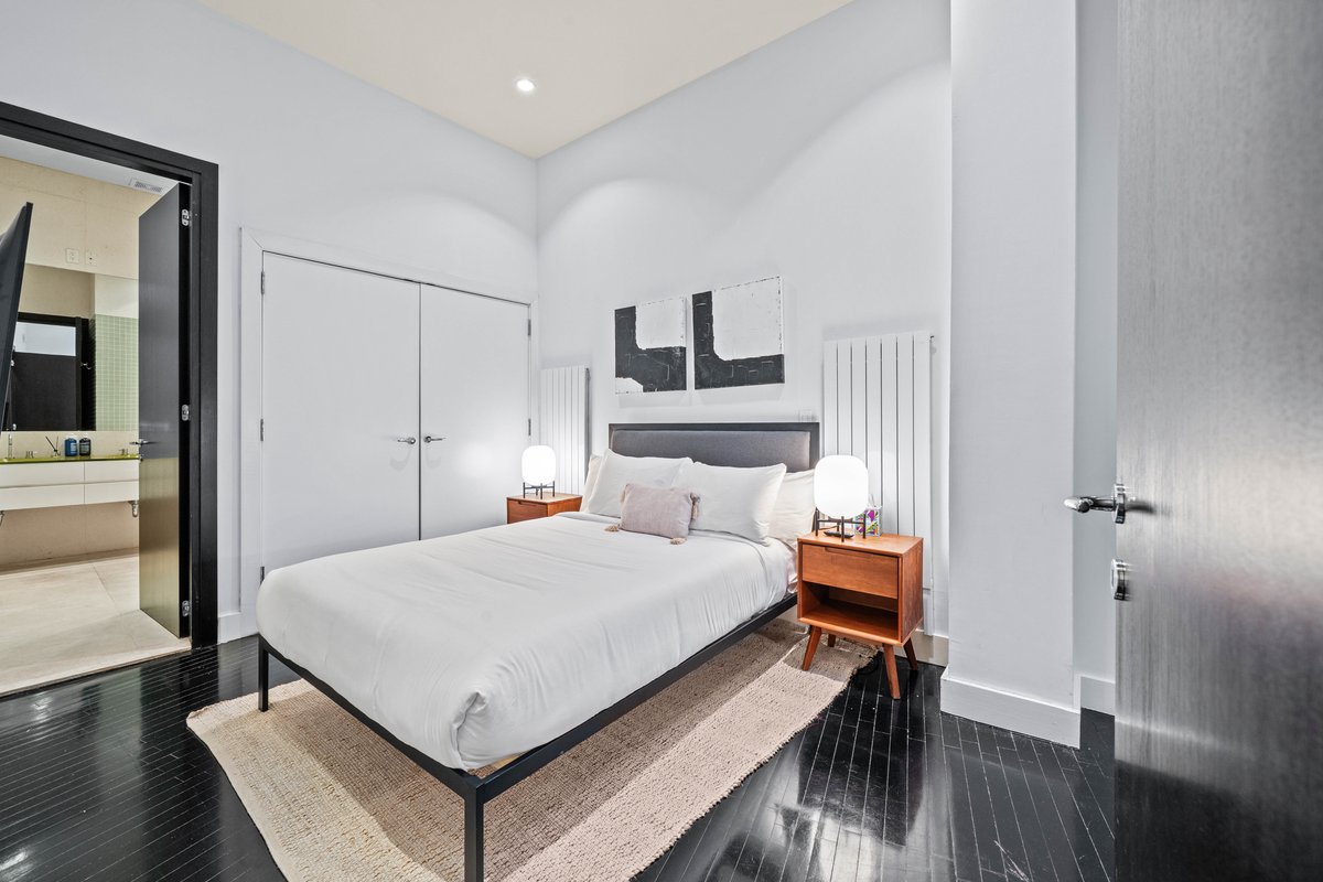 133 West 14th Street, Unit 1 Manhattan, NY 10011 - Photo 11 of 17 a bedroom with a bed and wooden floor