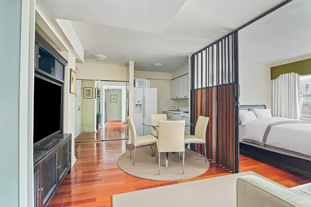 153 East 57th Street, Unit 17F Manhattan, NY 10022 - Photo 3 of 8 a dining room with furniture and a flat screen tv