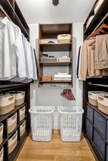 a view of walk in closet with clothes and shoes