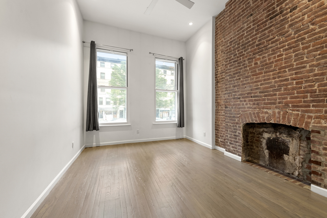 220 West 79th Street, Unit PARLOUR Manhattan, NY 10024 - Photo 5 of 9 an empty room with windows and a fireplace