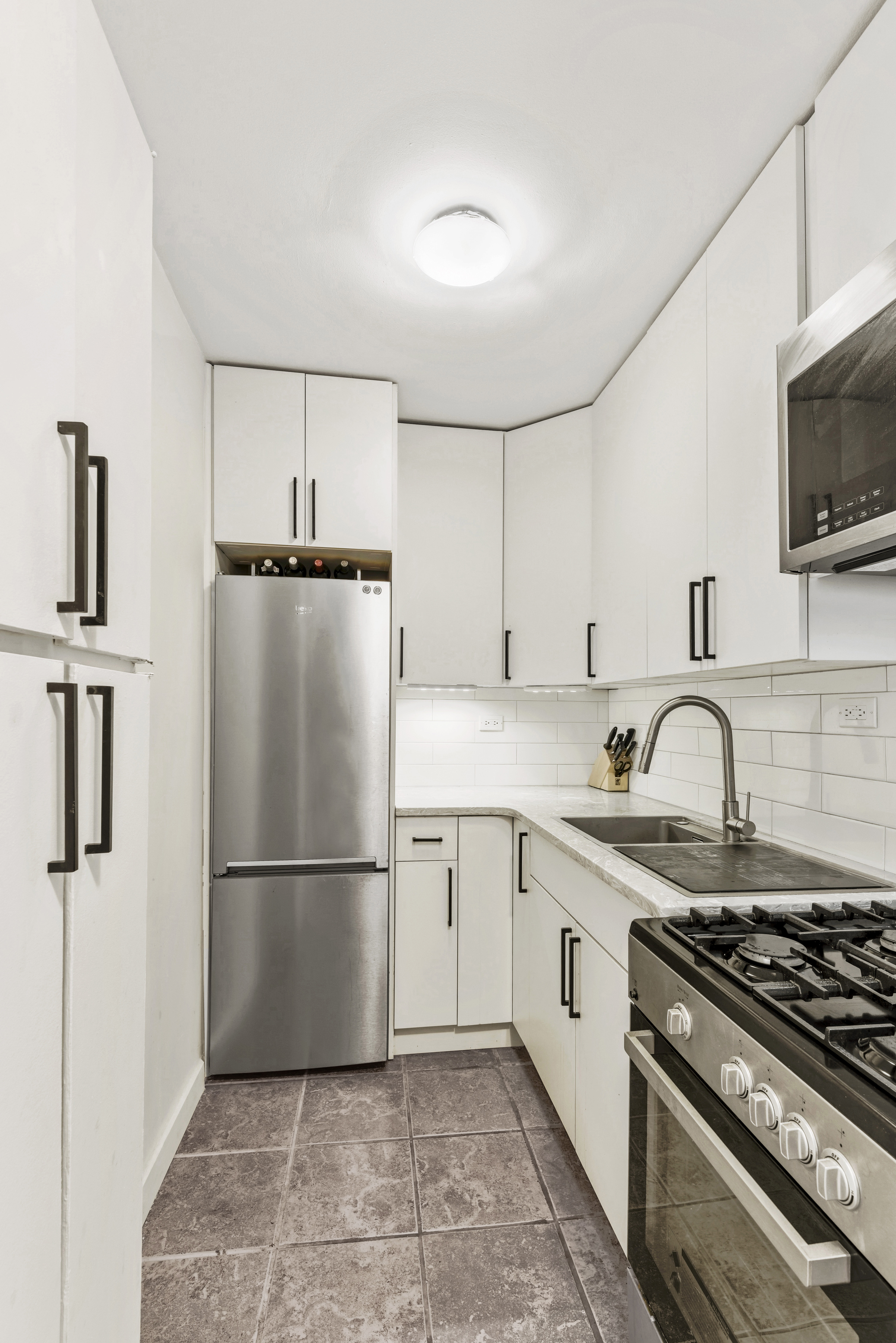 195 Willoughby Avenue, Unit 702 Brooklyn, NY 11205 - Photo 2 of 11 a kitchen with granite countertop a refrigerator stove top oven and sink