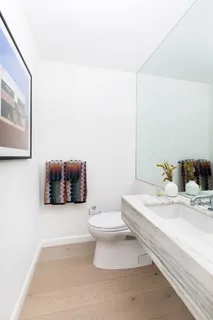a bathroom with a sink a toilet and mirror