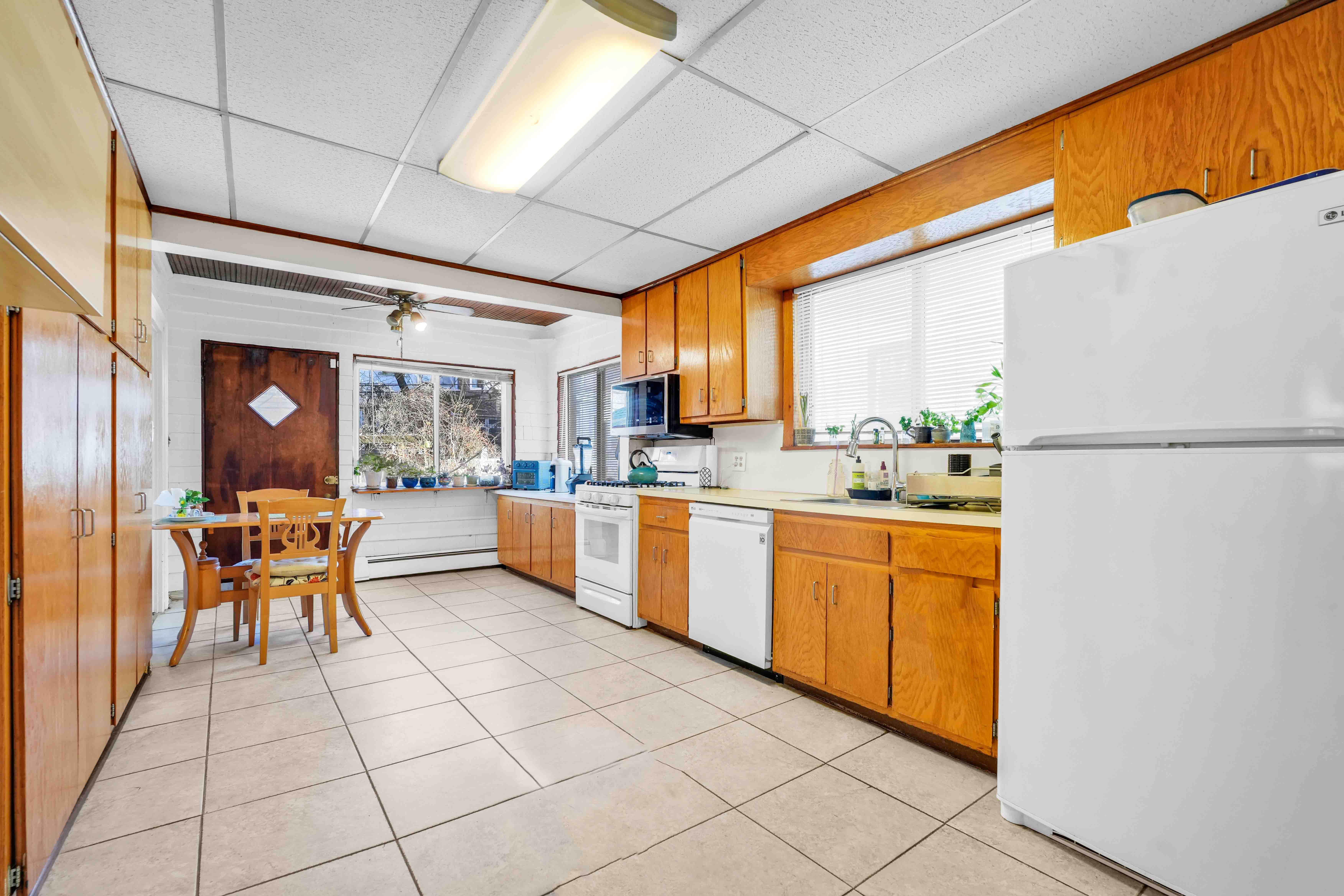 642 East 26th Street Brooklyn, NY 11210 - Photo 10 of 32 a kitchen with stainless steel appliances granite countertop a refrigerator a sink dishwasher and a dining table with the view of bathroom