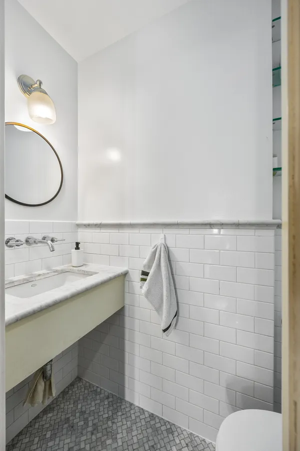 a bathroom with a granite countertop sink a toilet and a mirror