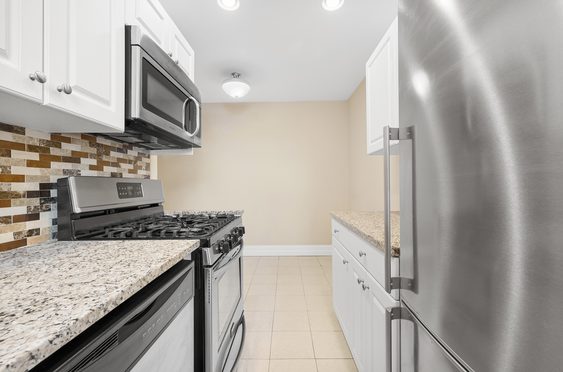 34-41 85th Street, Unit 4R Queens, NY 11372 - Photo 8 of 19 a kitchen with stainless steel appliances granite countertop a stove and a sink
