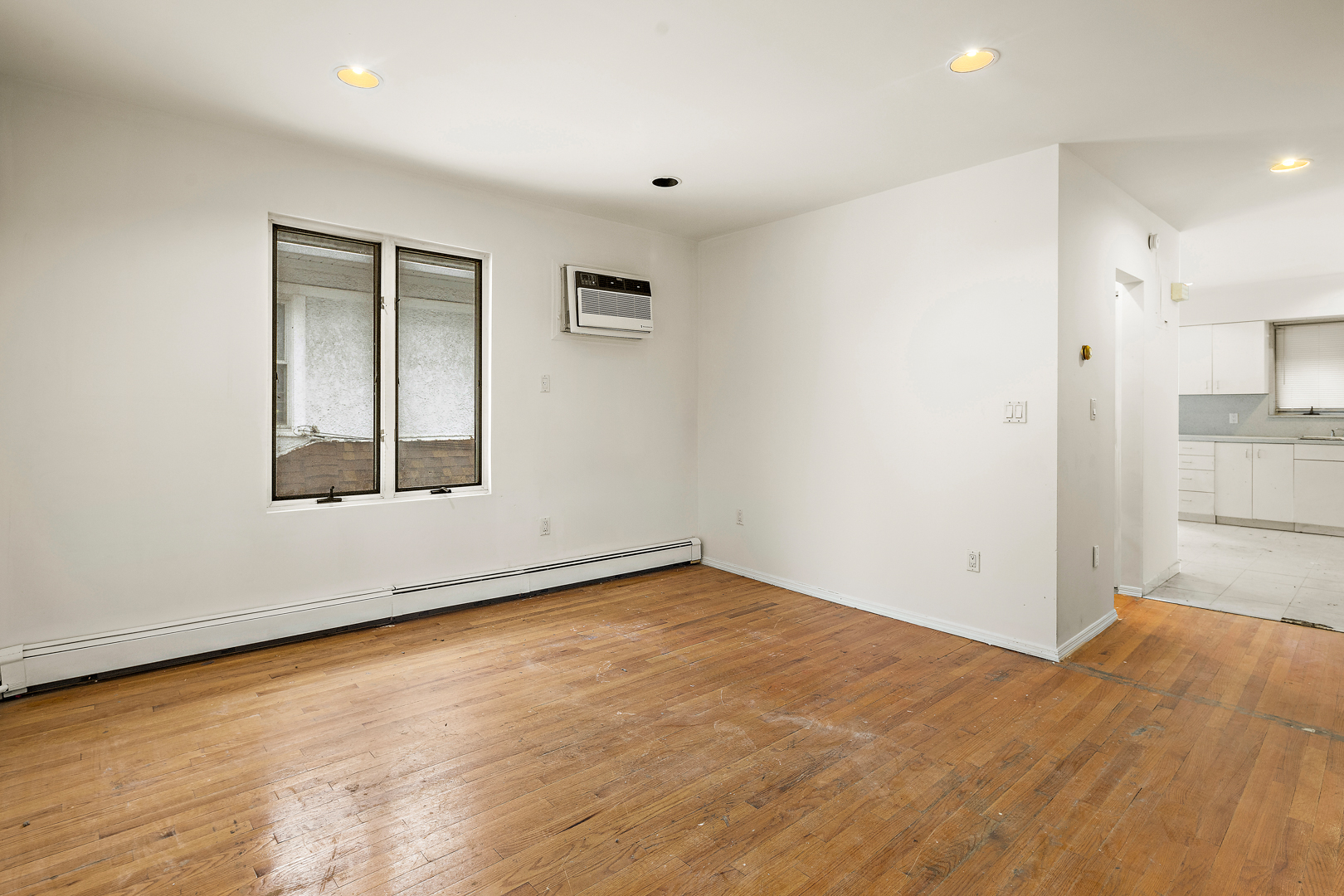 558 84th Street Brooklyn, NY 11209 - Photo 18 of 25 a view of an empty room with wooden floor and a window