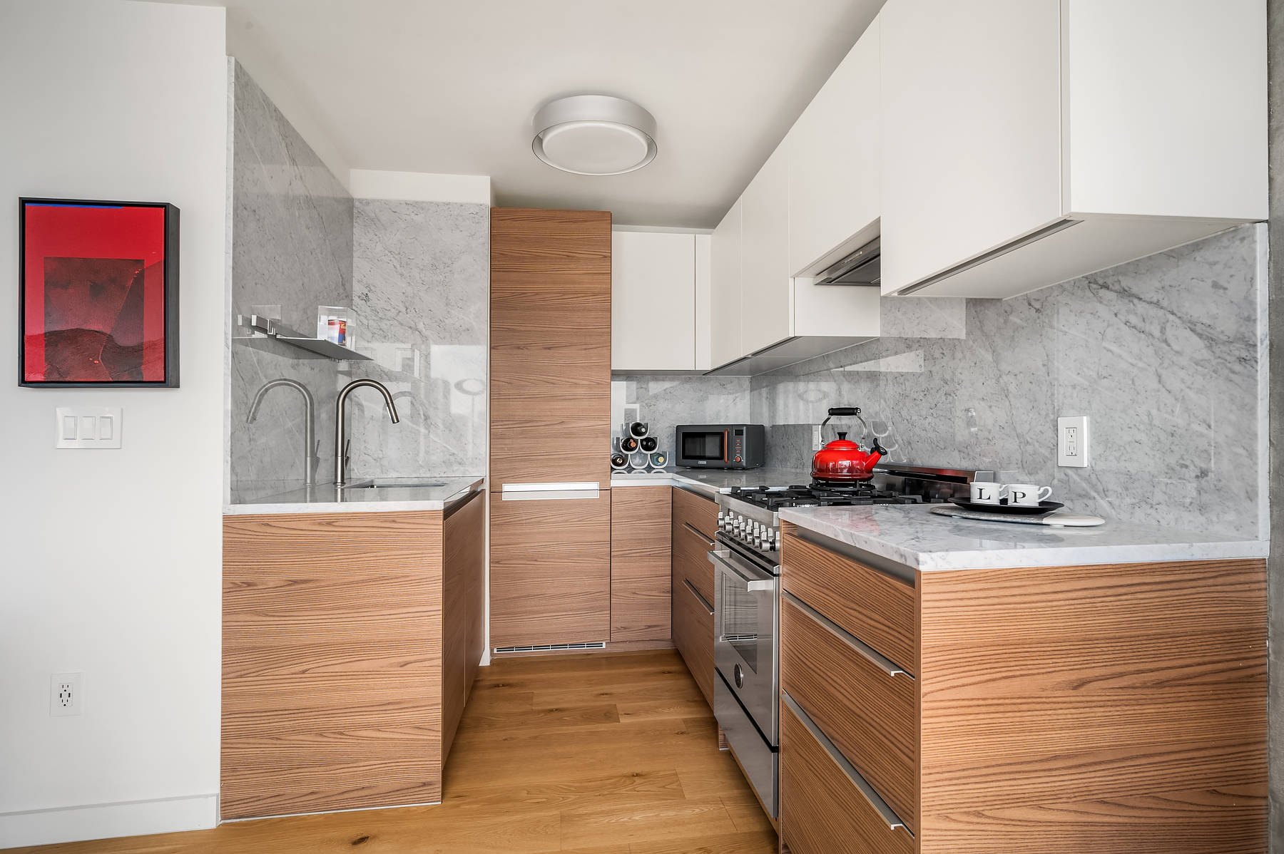 235 East 55th Street, Unit 44B Manhattan, NY 10022 - Photo 4 of 12 a kitchen with granite countertop cabinets stainless steel appliances and a sink