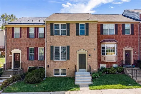 a front view of a house with yard and green space
