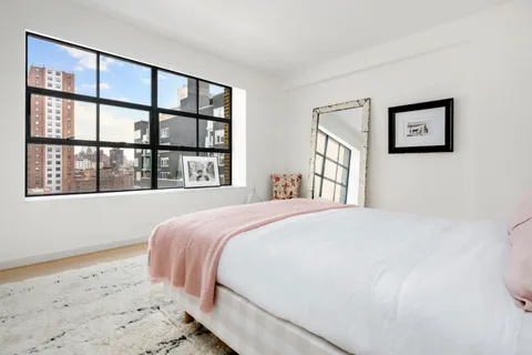 a bedroom with a large bed and a window