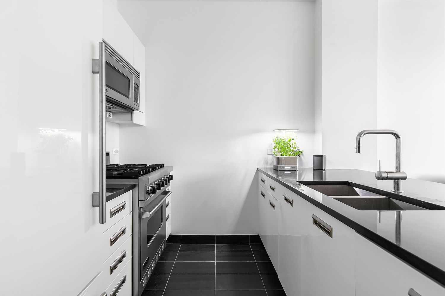 46-30 Center Boulevard, Unit 406 Queens, NY 11109 - Photo 4 of 24 a kitchen with a sink and stainless steel appliances