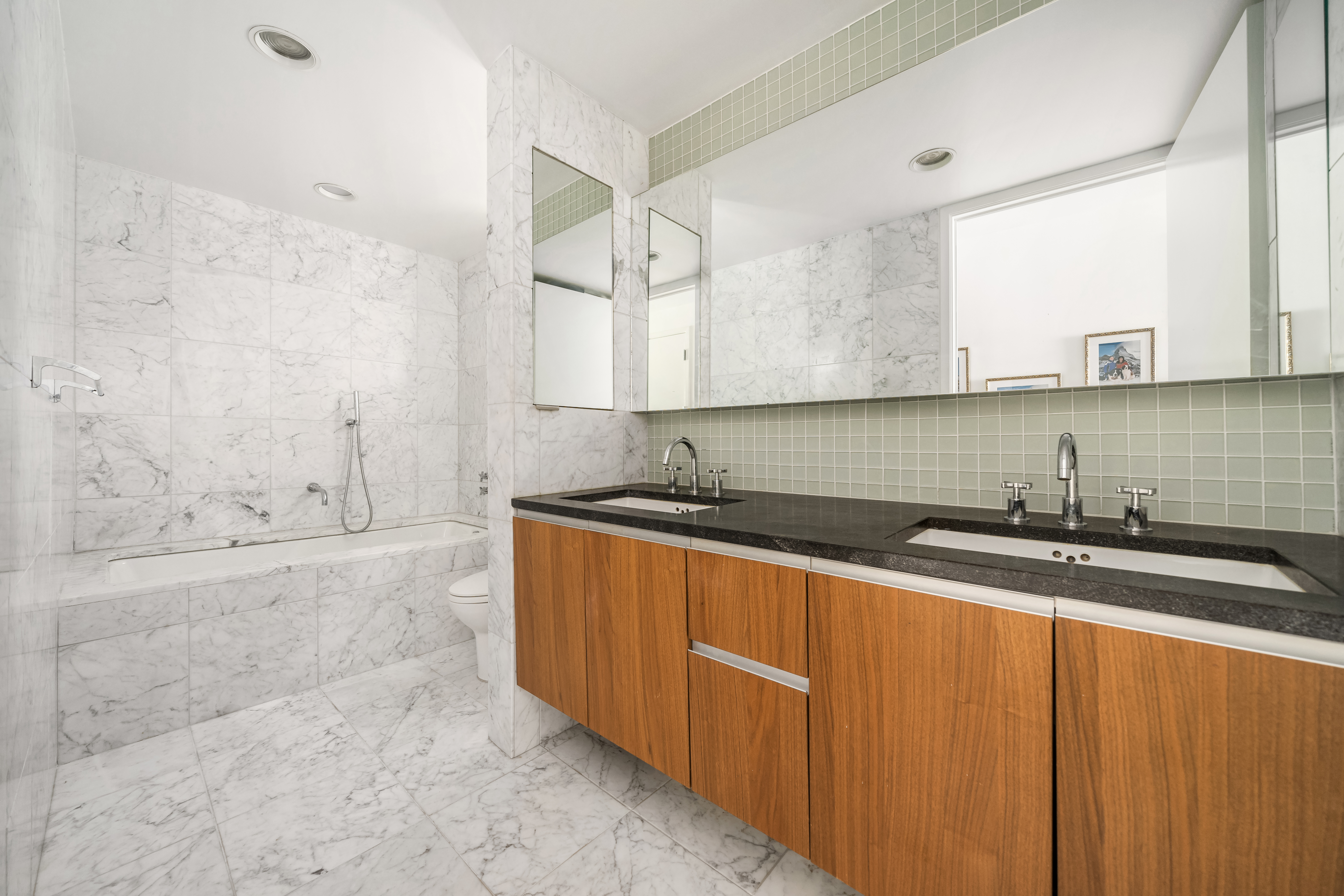 311 West Broadway, Unit 8A Manhattan, NY 10013 - Photo 6 of 10 a bathroom with a granite countertop sink a mirror and a bathtub