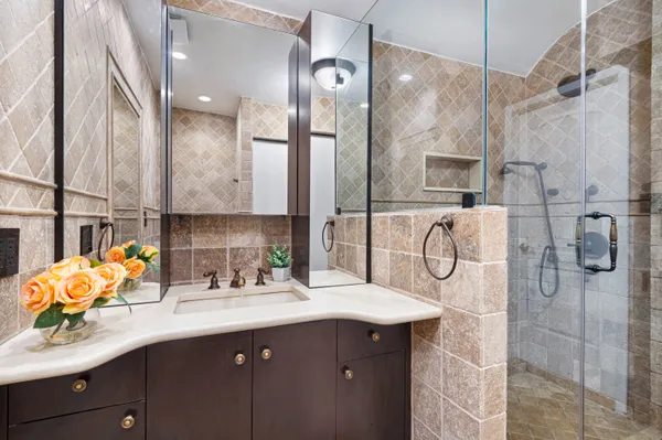 a bathroom with a sink double vanity mirror and shower