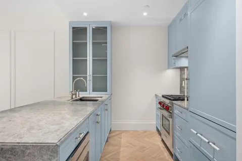 a kitchen with granite countertop a sink stove and cabinets