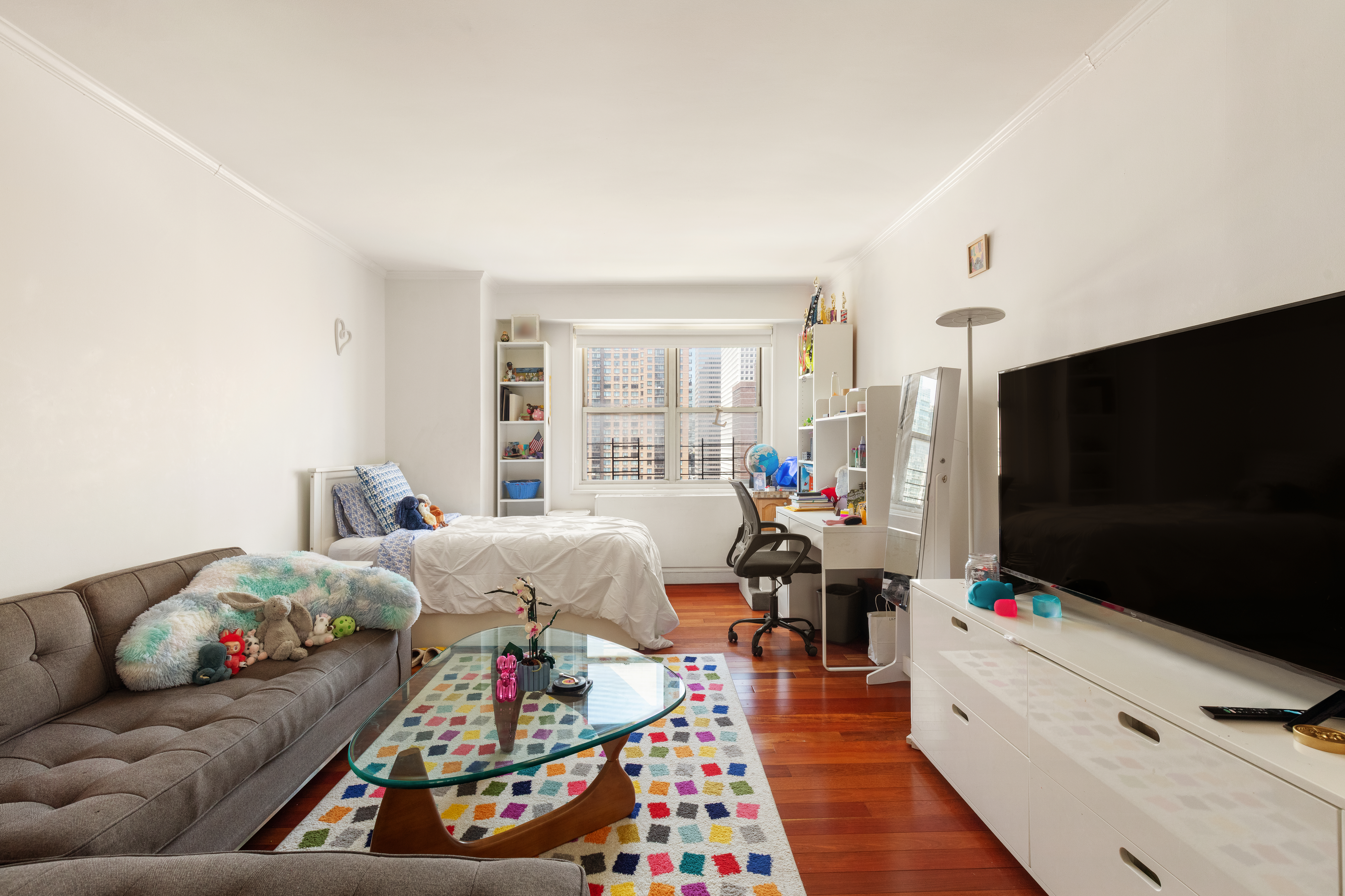 400 East 54th Street, Unit 21CDE Manhattan, NY 10022 - Photo 6 of 10 a living room with furniture and a flat screen tv