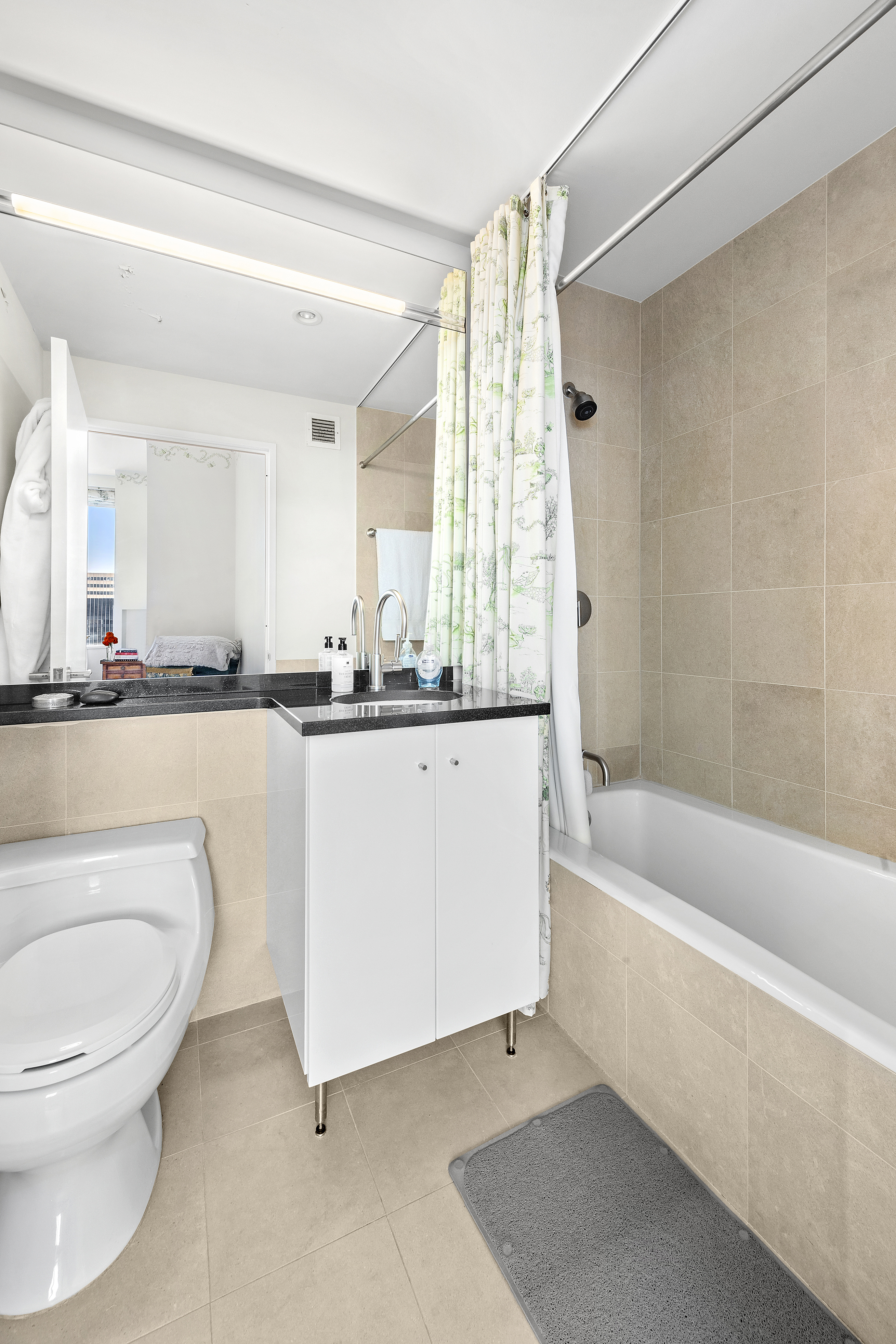60 East 55th Street, Unit 40B Manhattan, NY 10022 - Photo 6 of 12 a bathroom with a sink a toilet and bathtub