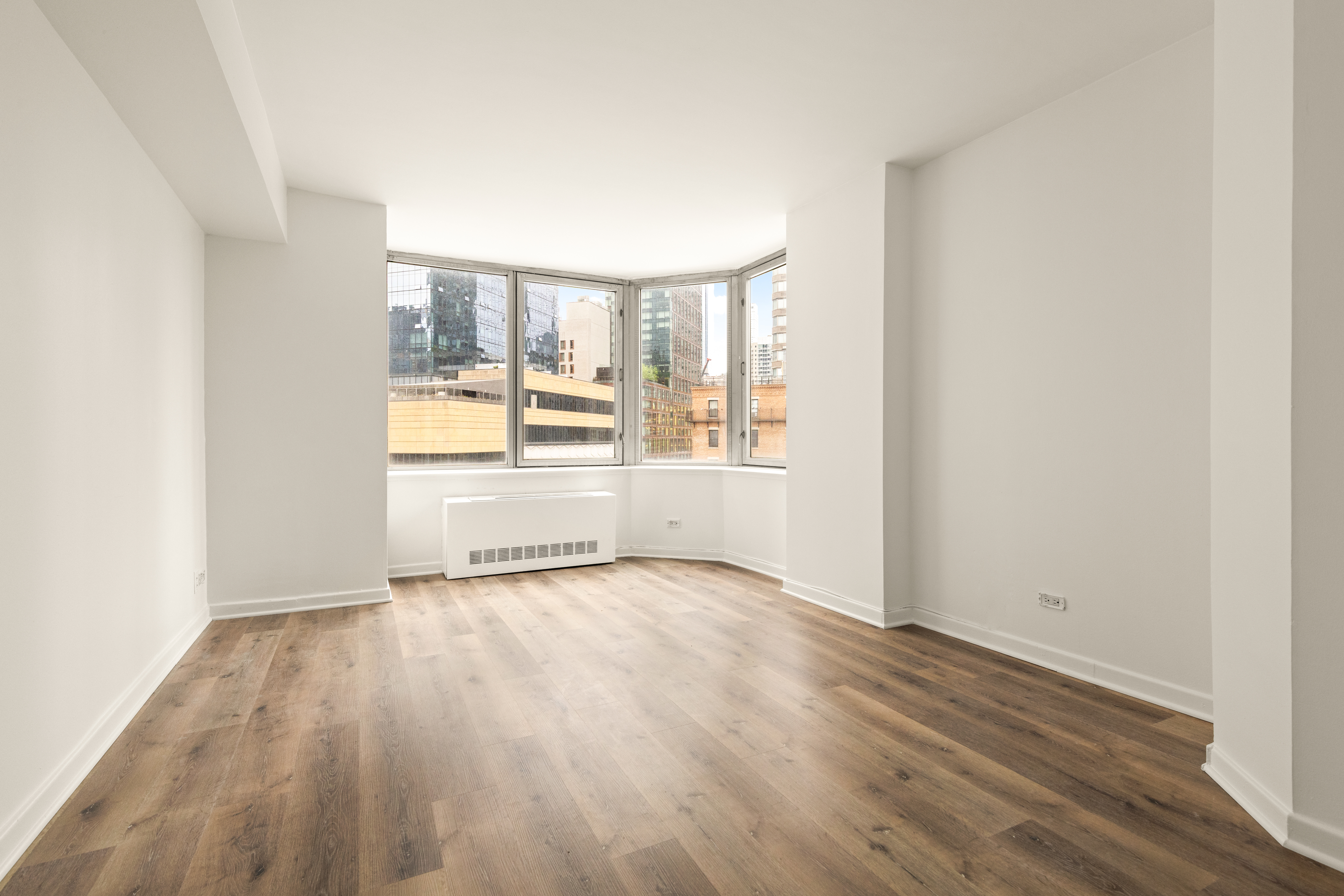 500 West 43rd Street, Unit 5C Manhattan, NY 10036 - Photo 2 of 9 an empty room with wooden floor and windows