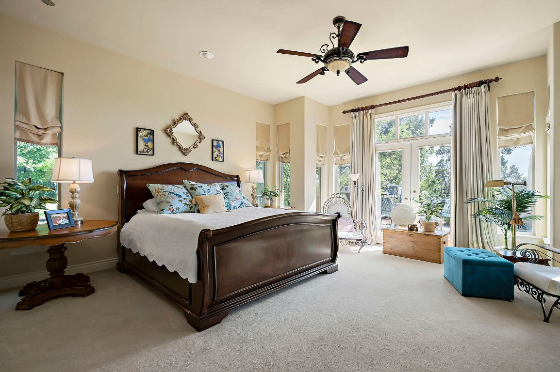1607 The High Road Austin, TX 78746 - Photo 16 of 28 a bedroom with a bed and a chandelier