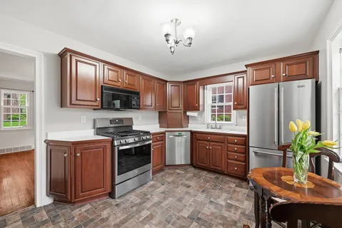 an empty room with wooden floor fireplace and windows