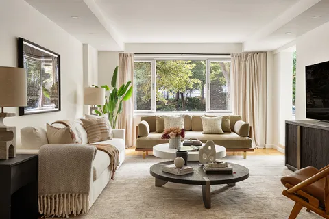a living room with furniture a flat screen tv and a large window