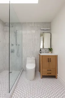 a bathroom with a granite countertop sink a toilet and a mirror