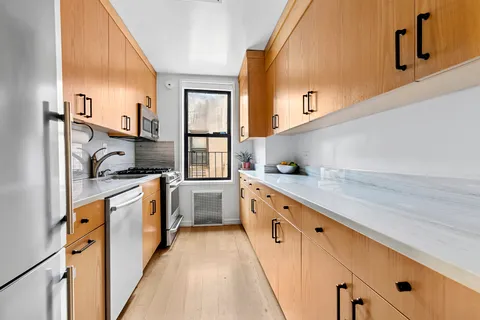 a kitchen with granite countertop white cabinets and white appliances